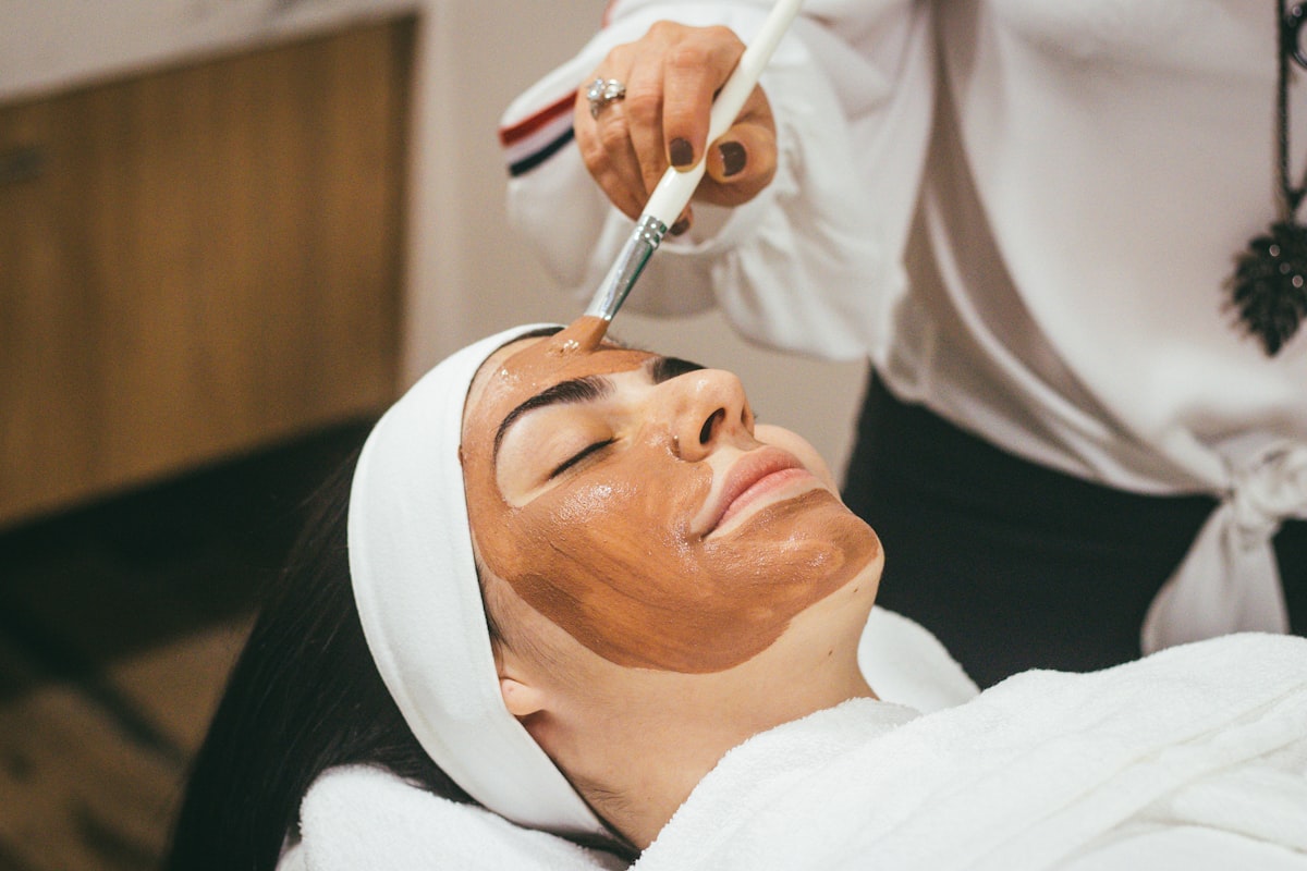 Brightening mask being brushed on during a facial treatment